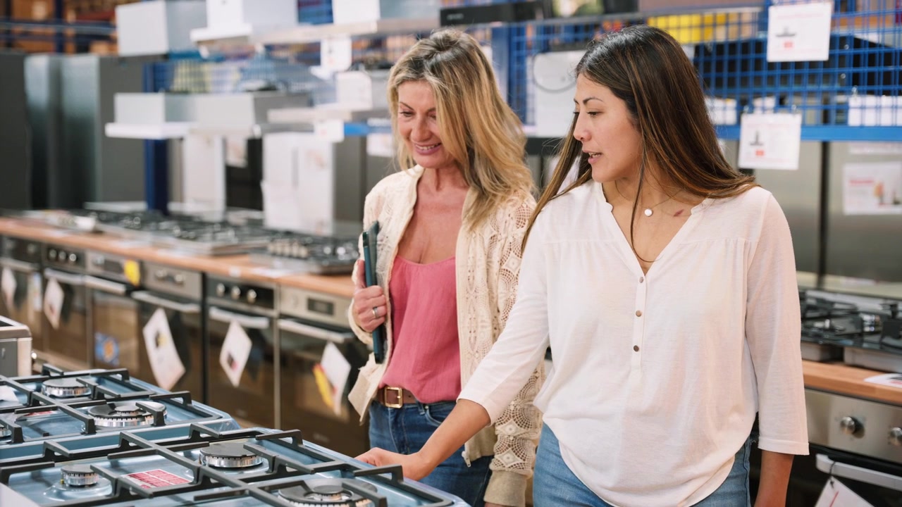 Due Donne che Acquistano una Cucina a Gas in un Negozio di Elettrodomestici