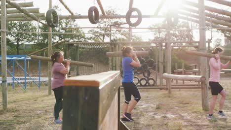 Female-friends-enjoying-exercising-at-boot-camp-together