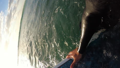 pov shot of a man surfing on a longboard, along the waves of riverton