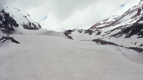 tiro de drone volando a través de la cordillera nevada