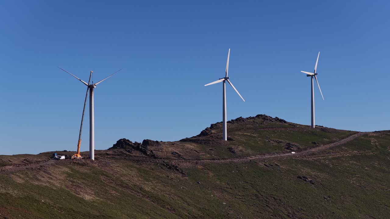 Renewable energies wind turbines park with crane reparation