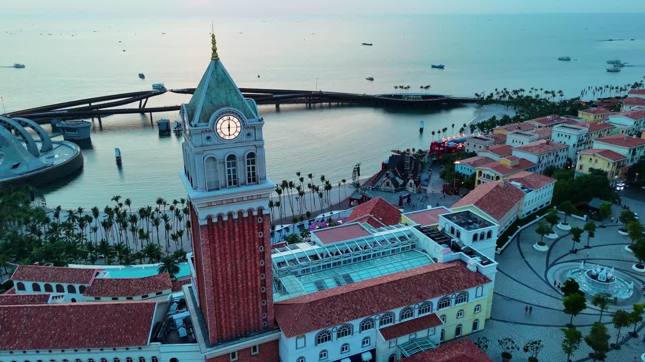 Aerial view of a replica of St. Mark's Campanile Clock Tower in the Italian-style City of Phu Quoc Island, Vietnam, with the sunset casting a warm glow over the coastal landscape.