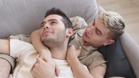 couple lying sofa at home and hugging