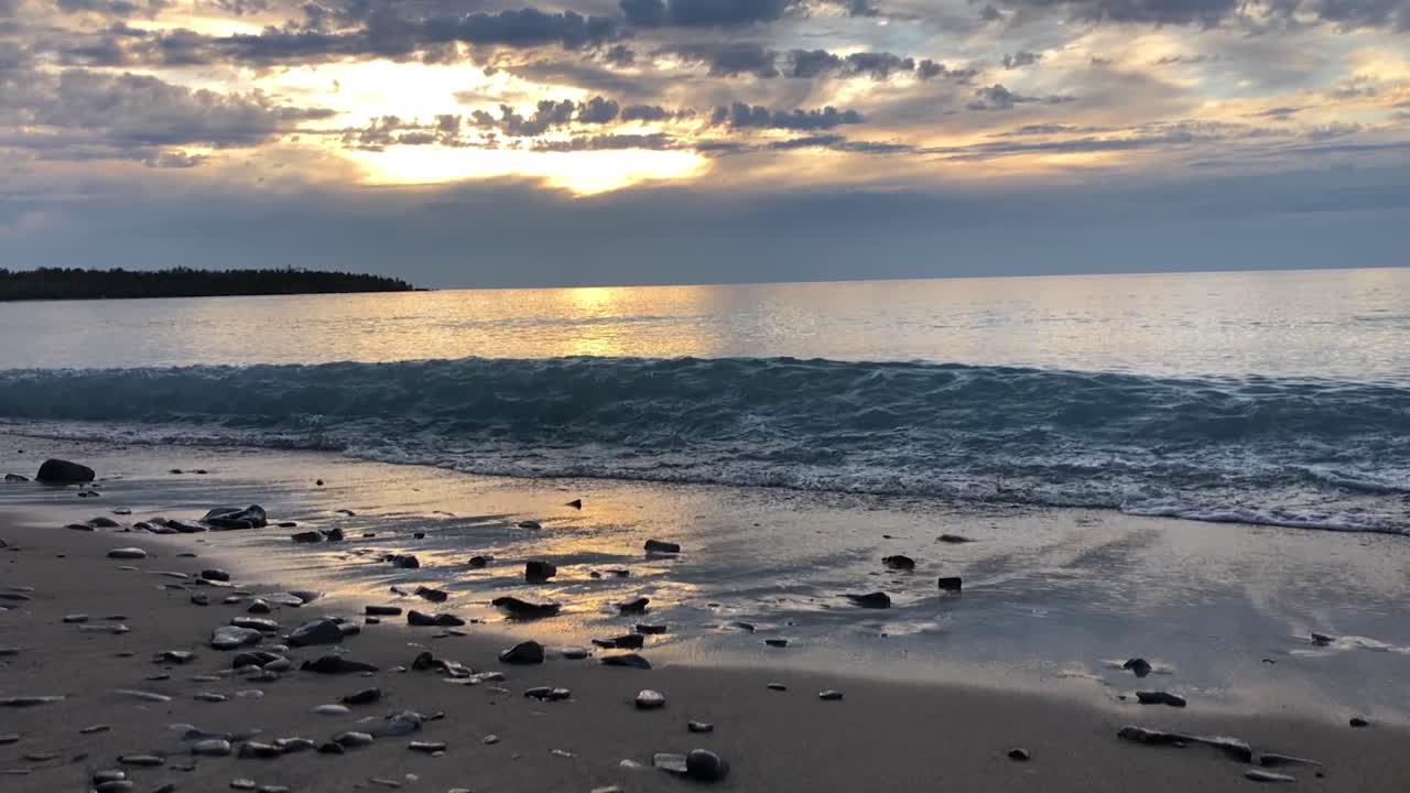 Lake Superior waves crashing on the beach during sunset in Michigan in slow motion