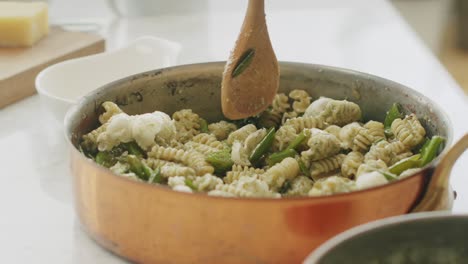 mujer de la cosecha mezclando pasta en la sartén