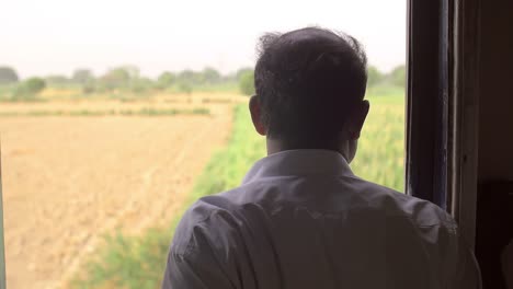 man looking out of train