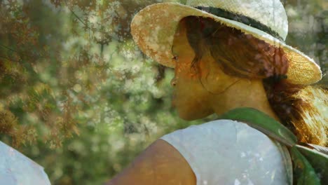 video compuesto de una mujer afroamericana con un sombrero sonriendo contra árboles altos