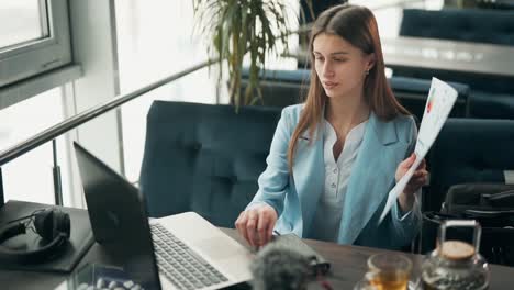 close-up portrait of a young business lady giving a presentation in a cafe via laptop