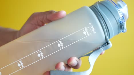 person holding a gray water bottle