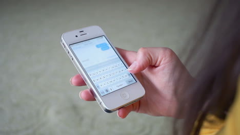 mensajes de texto en el teléfono inteligente. iphone en la mano con internet. mujer usando teléfono inteligente