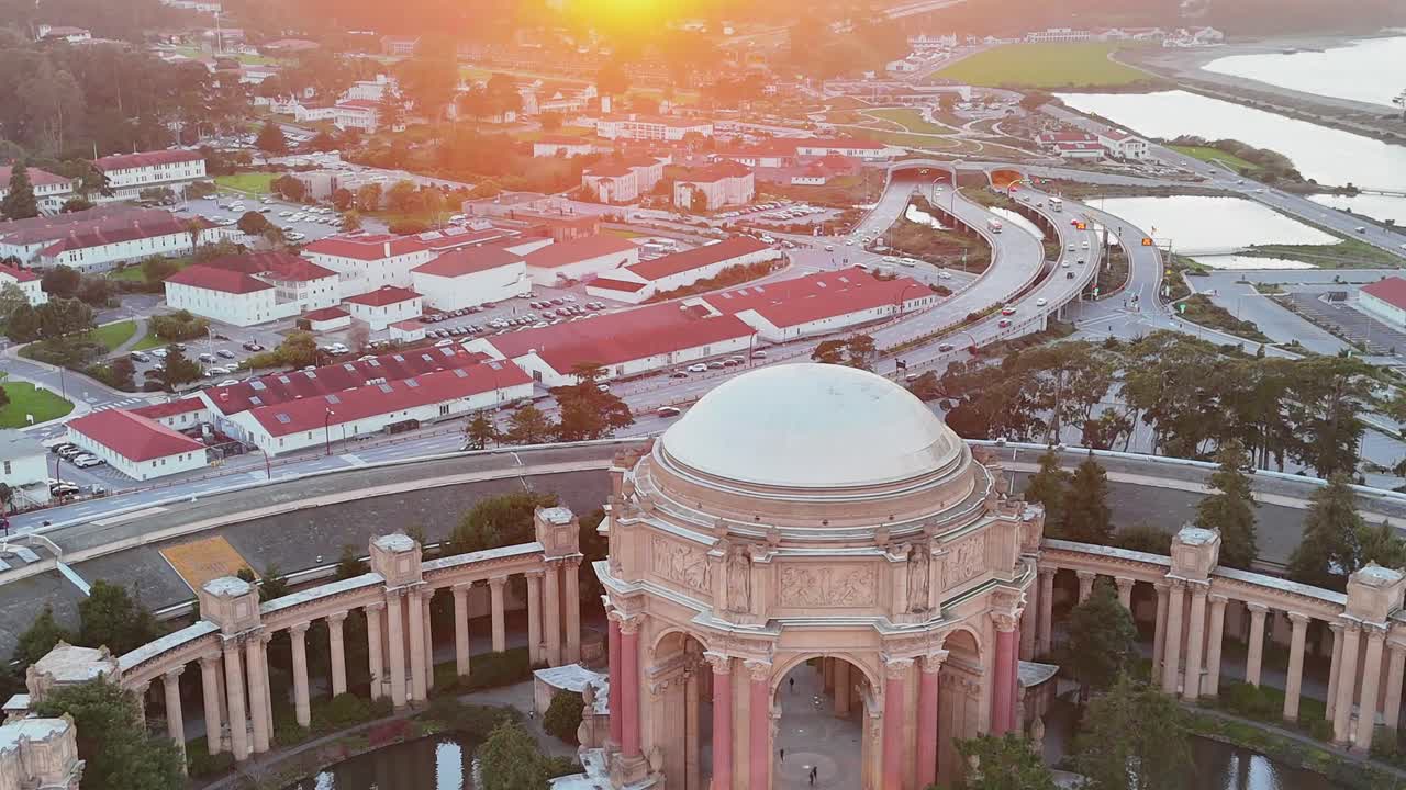 Aerial drone shot of the Palace of Fine Arts in San Francisco at sunset, highlighting the dome, lagoon, and cityscape in warm evening light