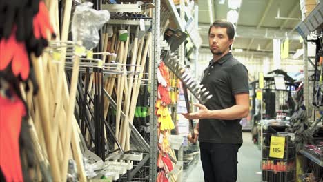 hombre comprando herramientas de jardinería en una tienda
