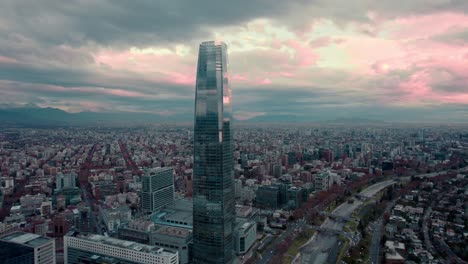 dolly out aerial view of the costanera tower with cloud reflections at sunset after the rain, santiago, chile