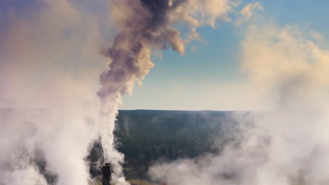 dramatic drone pov of harmful greenhouse gases emitted from factory smokestack