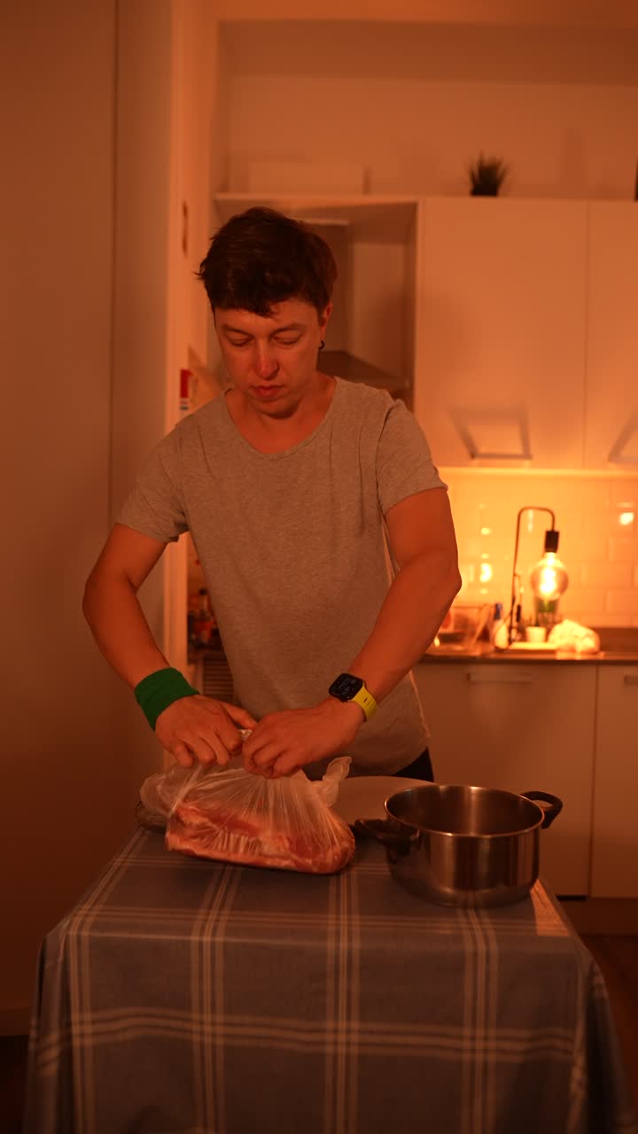 hombre preparando carne de cerdo cruda en una cocina