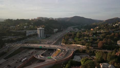 panorámica aérea de aumento lento de patrones de tráfico durante la hora pico en la autopista en el oeste de los ángeles