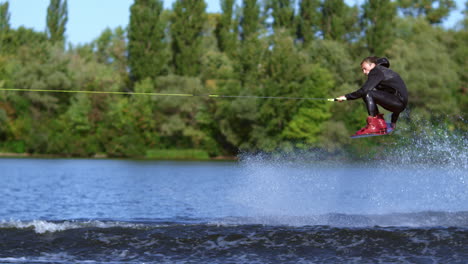 Wakeboarder-Springt-über-Wasserwelle.-Schlanker-Mann-Beim-Wakeboarden-über-Wasser