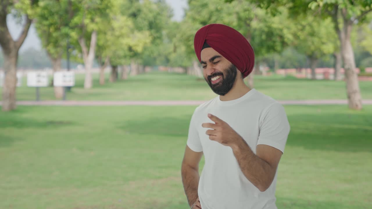 hombre indio sikh feliz riendo en el parque
