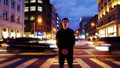 man standing in a city street at night