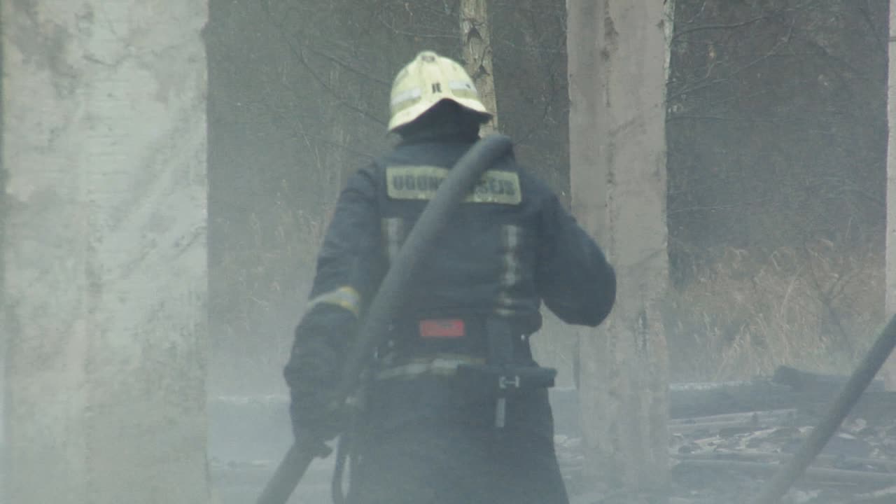 los bomberos dirigen el chorro de agua sobre la casa en llamas