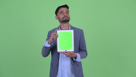 joven y guapo empresario persa barbudo en traje
