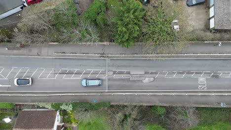 Autos,-Die-Um-Ein-Großes-Schlagloch-Auf-Einer-Britischen-Straße-Herumfahren,-Aus-Der-Vogelperspektive,-Drohnenantenne