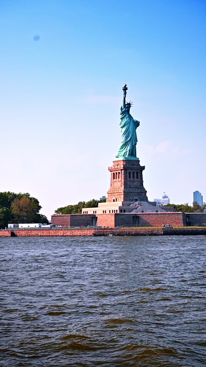 New York, USA, 8 July 2025: Visiting the iconic statue in New York. Tourists admire the majestic statue overlooking the harbor on a sunny day in New York City