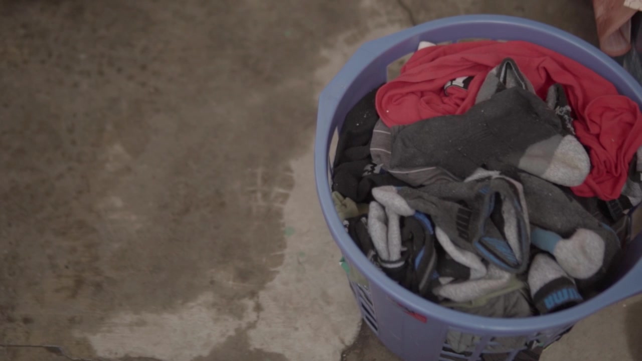 Close up view of laundry basket filled with assorted clothes during household chore activity highlighting washing organization and domestic routine