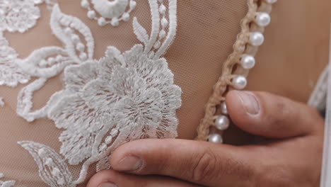 groom hugs woman wearing elegant lacy dress at wedding