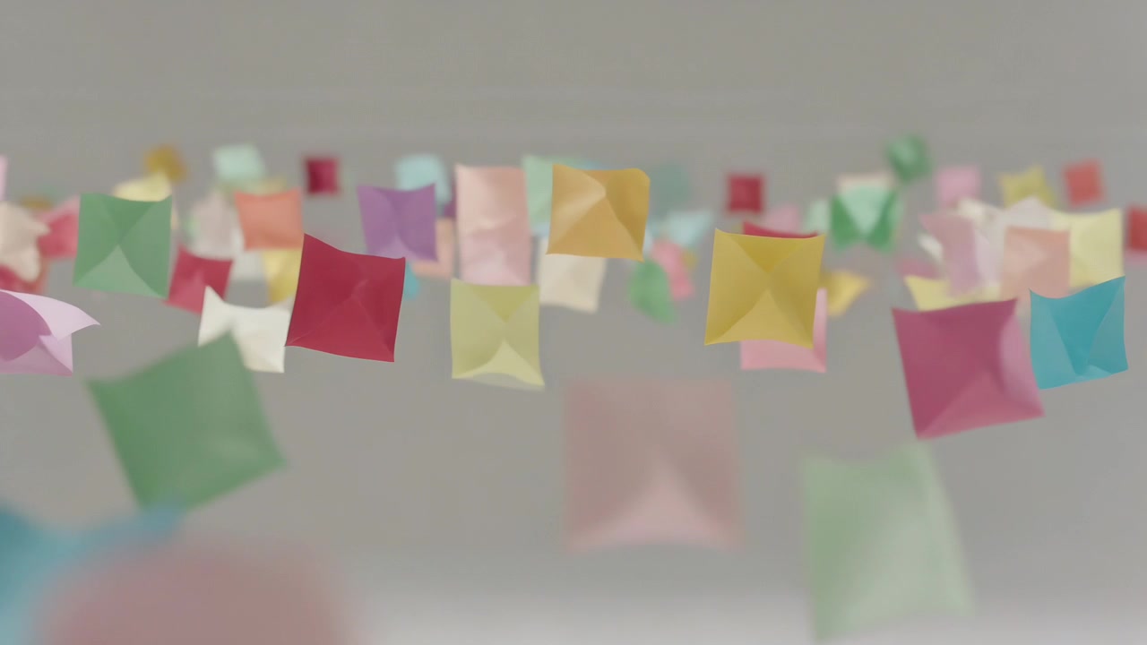 Swaying cluster of pastel paper pouches drifting across gray studio backdrop, airflow initiating