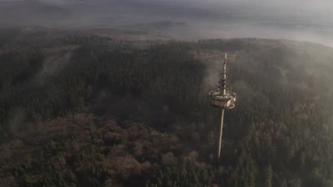 aerial view of a transmission tower in a foggy forest