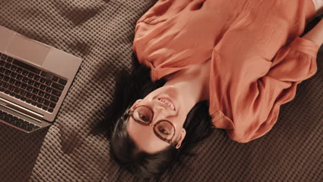 caucasian woman lying on bedcover smiling