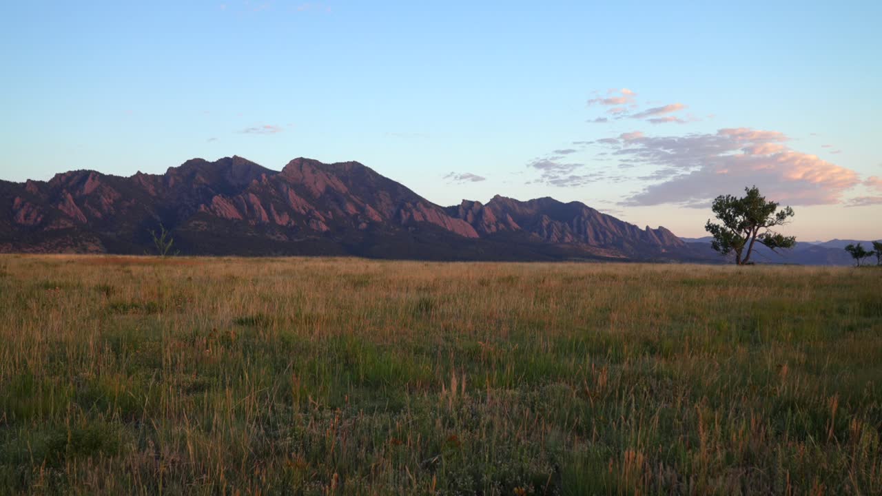Flatirons Front Range Boulder Chautauqua Park morning sunrise aerial drone Colorado spring summer pink cloud first light on red slanted scenic nature boulder Rocky Mountains windy tree pan right