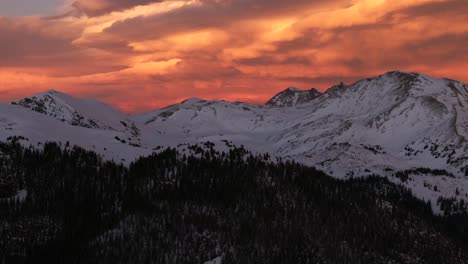 glorious purple high elevation rocky mountains setting sunset orange vibrant cloudy skies winter solstice colorado aerial drone i70 coon hill parshall eisenhower tunnel continental divide forward pan