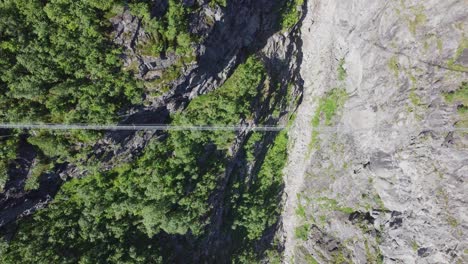 via ferrata bridge at mount hoven in loen seen from above - birdseye aerial norway with unrecognizable person passing bridge