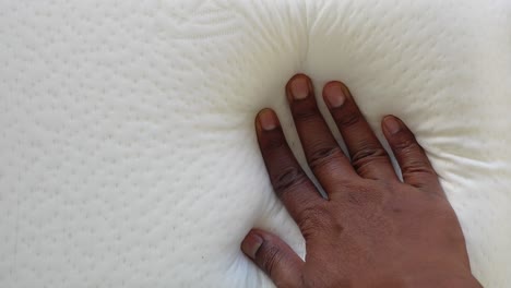 mano en un colchón blanco