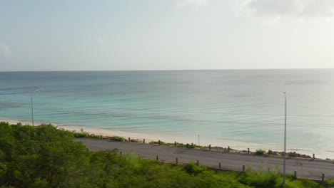 Aerial-view-open-roof-4wd-drive-on-Antigua-and-Bermuda-coast-surrounded-by-ocean-and-green-nature-in-Caribbean