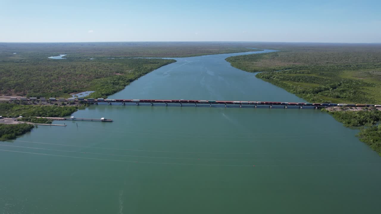 Freight train crossing a river bridge -outback Australia. Drone, wide