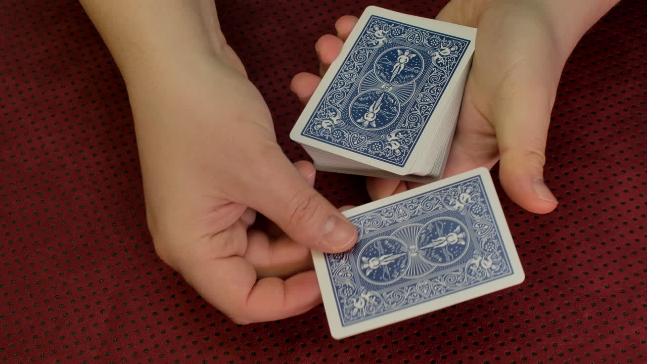 primer plano de las manos de un mago haciendo un truco de cartas