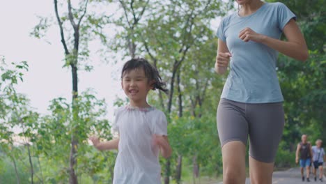 mother and daughter running in park