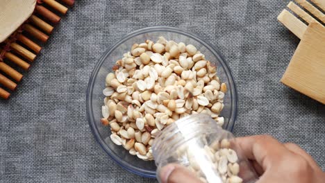 slow motion of peanuts pouring in a bowl on table