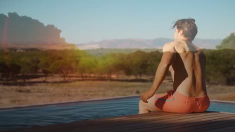 Hombre-Sentado-En-La-Terraza-De-Una-Piscina