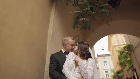 newlyweds, caucasian groom with bride walking, embracing, hugs in city, wedding couple in love
