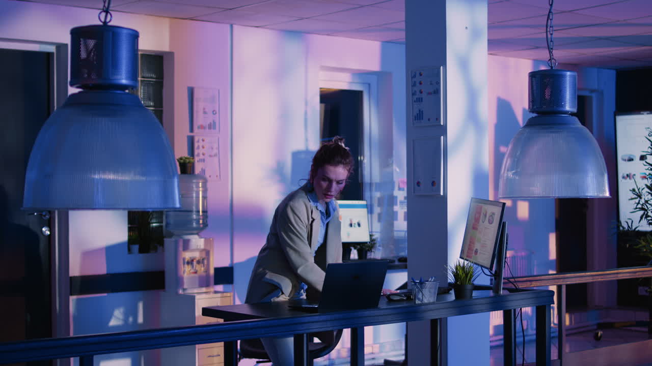 Office Interior with Desks, Computers, and a Woman Working
