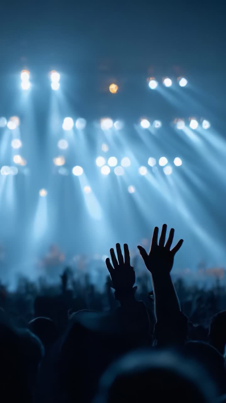 Capturando la energía de un concierto en vivo: fans levantan las manos con entusiasmo bajo luces deslumbrantes, dejándose llevar por la atmósfera mágica de una actuación memorable