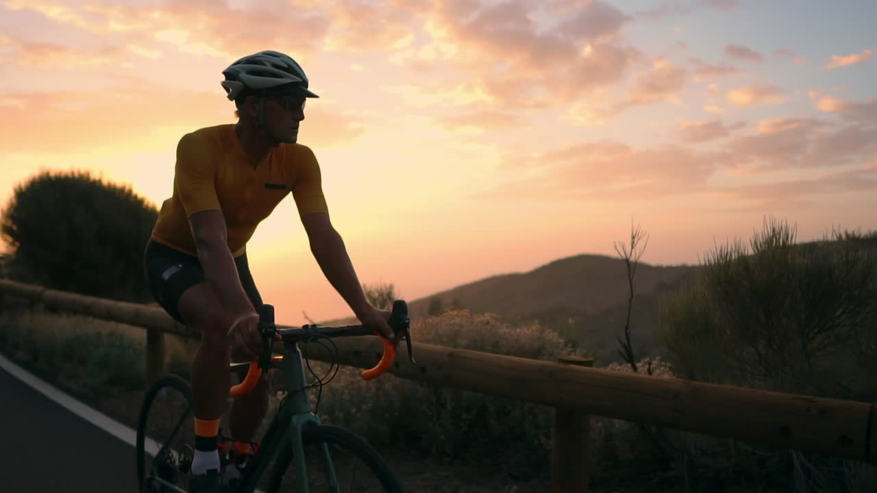 In slow motion, athlete on a bicycle traverses a mountain serpentine, basking in the island's beauty, a true embodiment of a healthy lifestyle