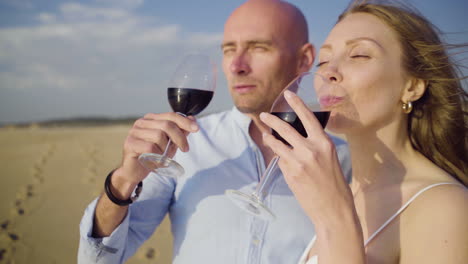 Couple-drinking-wine-and-kissing-on-beach