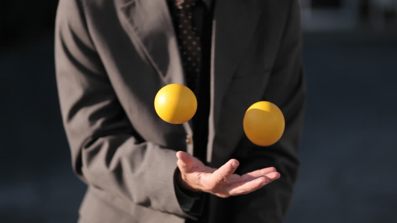 el hombre estaba haciendo malabarismos sin esfuerzo con 3 pelotas en la tarde
