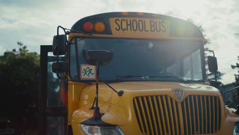 Front-view-school-bus-staying-terminal-with-open-door-waiting-students-close-up.