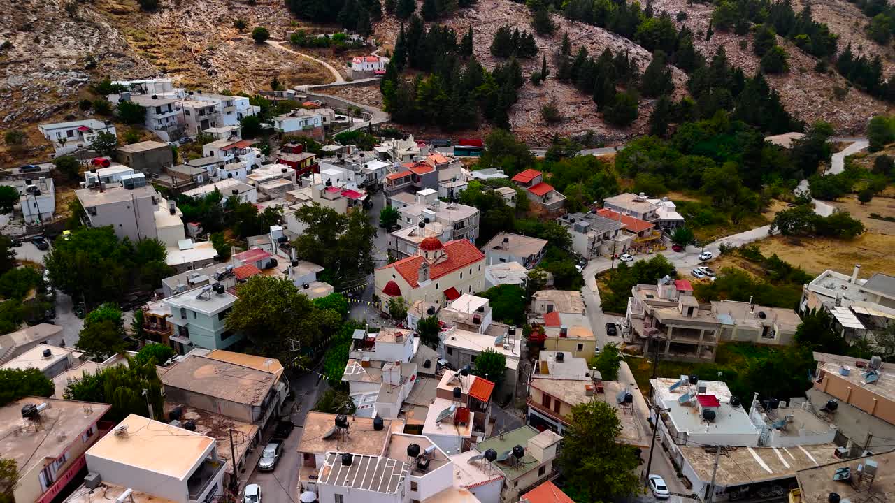 A stunning aerial view captures the beauty of a mountain village in Lebanon, highlighting the mix of homes and natural landscapes surrounded by hills and greenery